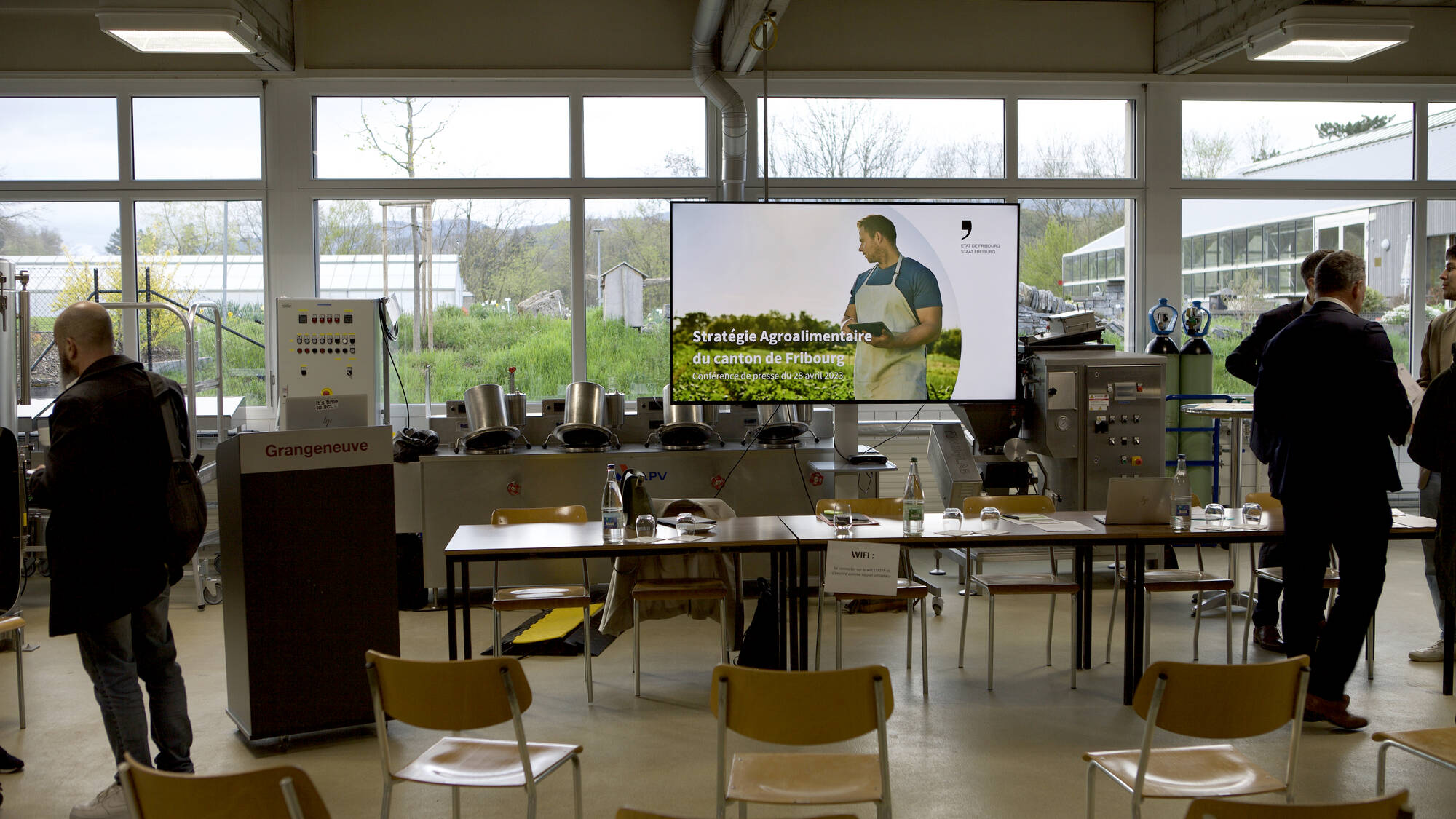 table de la Conférence de presse avec un écran montrant la stratégie agroalimentaire du canton de Fribourg